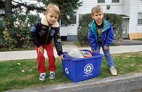 Boys placing blue box on curb